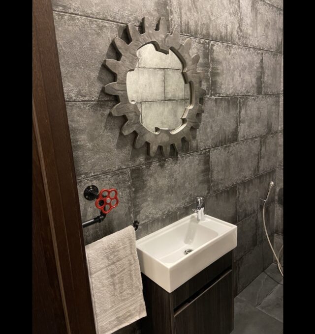 Зеркало шестеренка сталь на бетонной стене