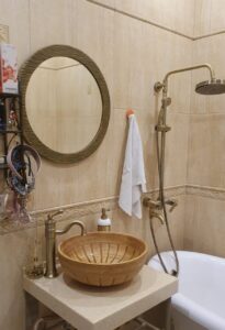 Зеркало в круглой раме латунь на стене в ванной